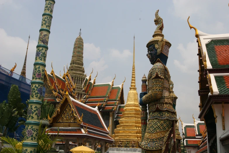 a statue on the top of the building and gold spires