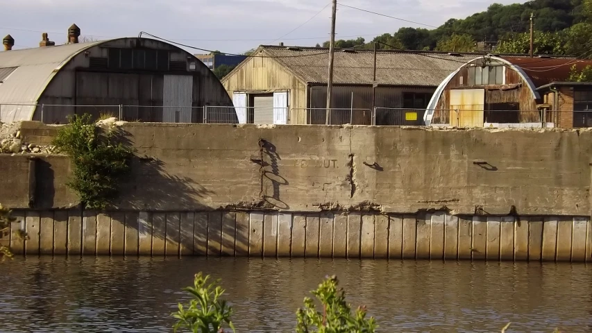 a concrete dam wall with silos and old factories