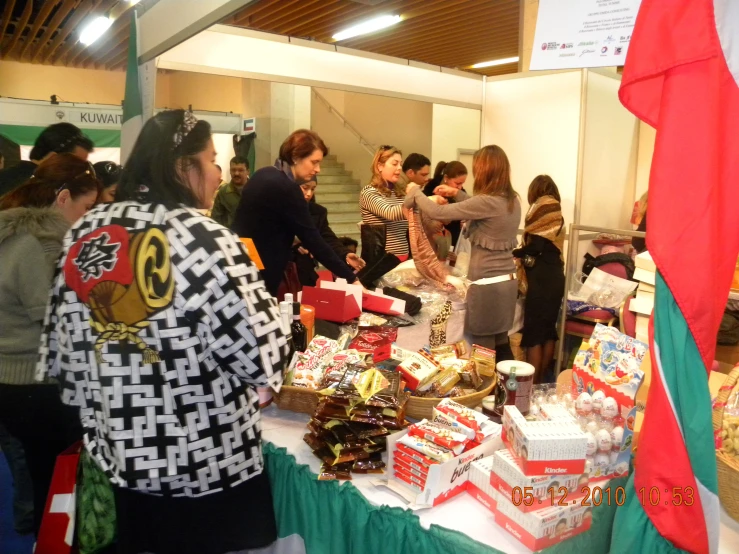 a group of people are looking at things on a table