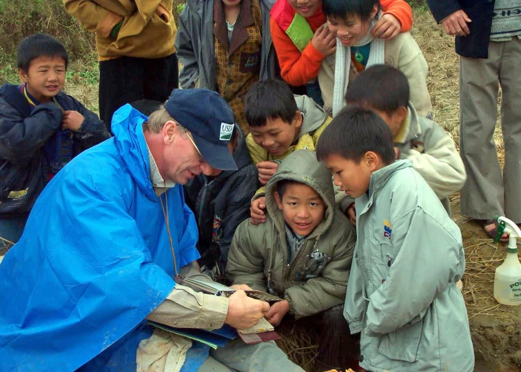 a group of s standing around an older man