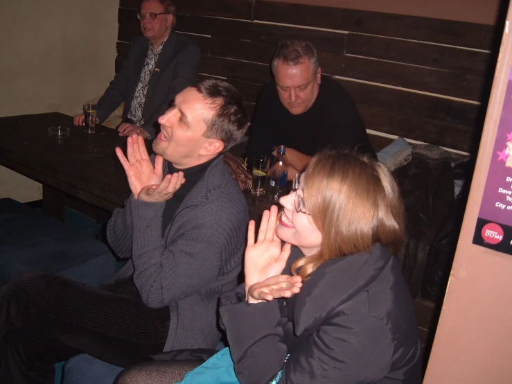 people sitting at a table clapping in a restaurant