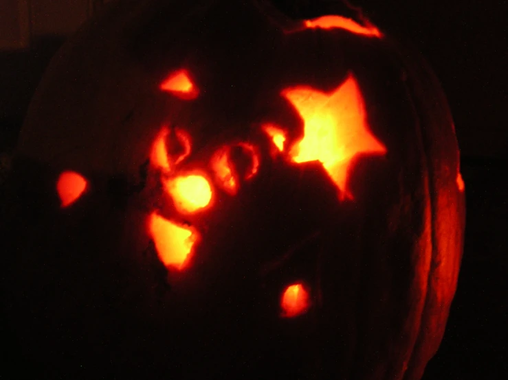 a carved pumpkin with several different faces and words carved into it