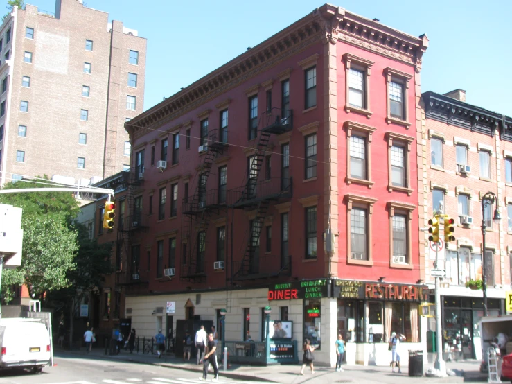 an old red building sits at the corner of a busy street