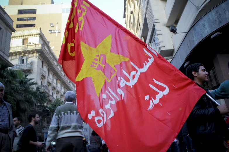 the man is holding a flag in his right hand