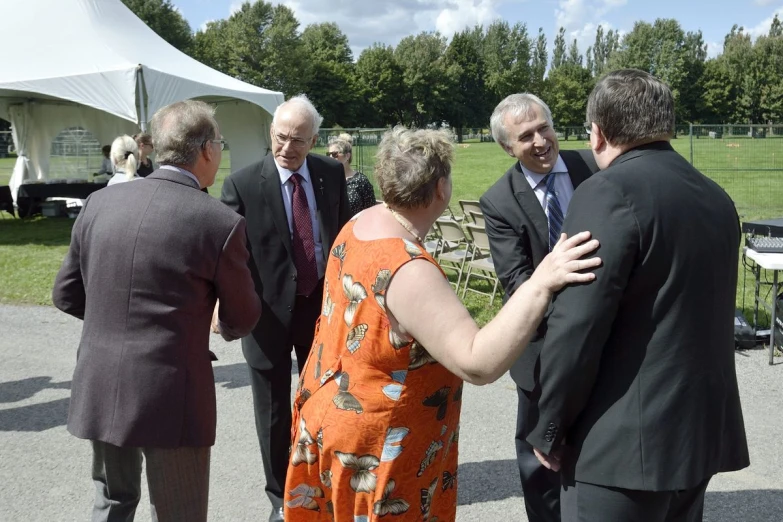 a group of people standing around each other near a tent