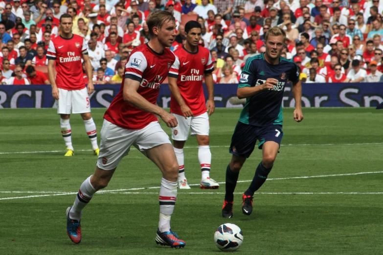 two soccer players with red and blue uniforms are competing