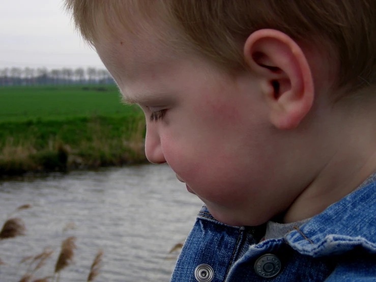 a toddler looking away at the water
