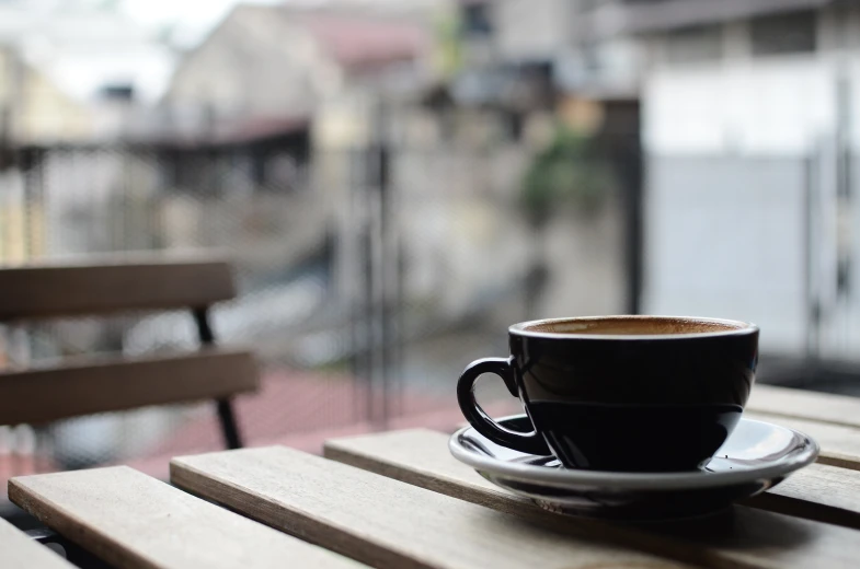 a wooden table topped with a cup of coffee