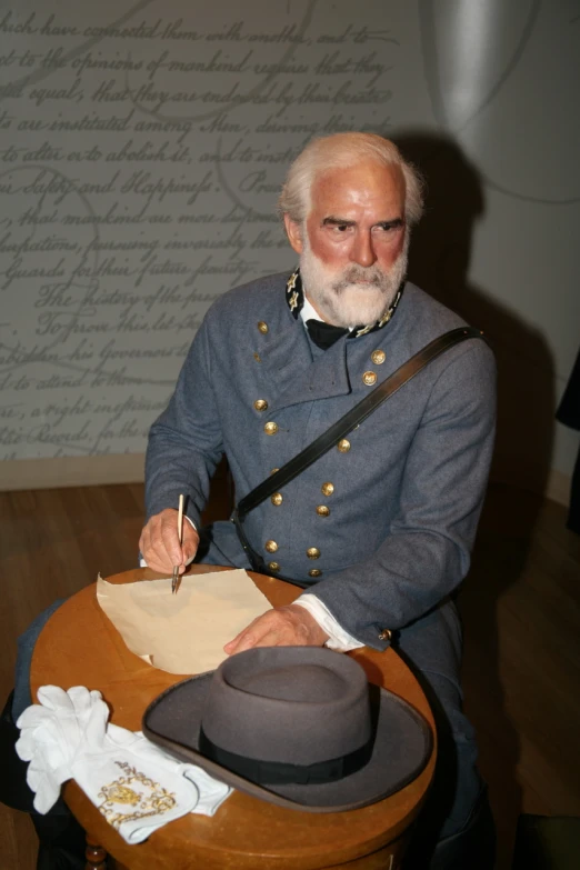 an older man in uniform signing soing at a table