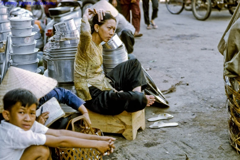 a young man on the street sitting next to a woman