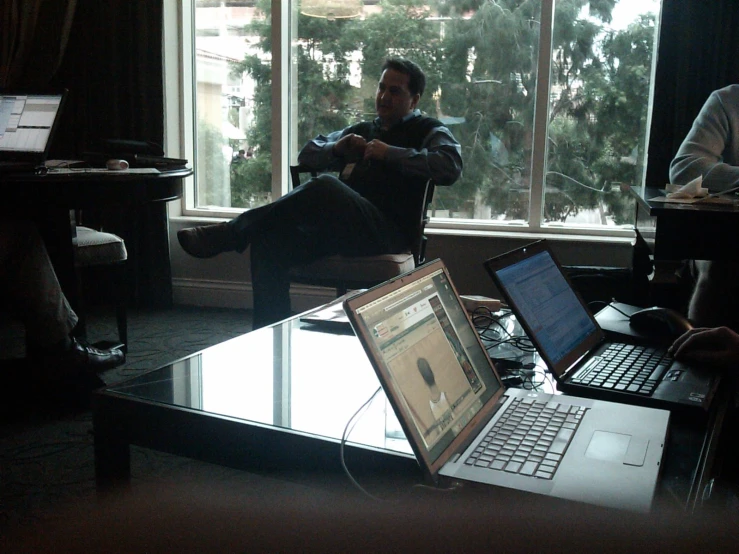 a man sitting in a chair with his laptop computer