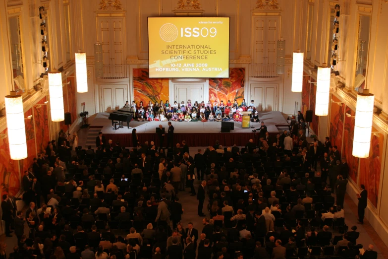 people standing and sitting in front of a large stage