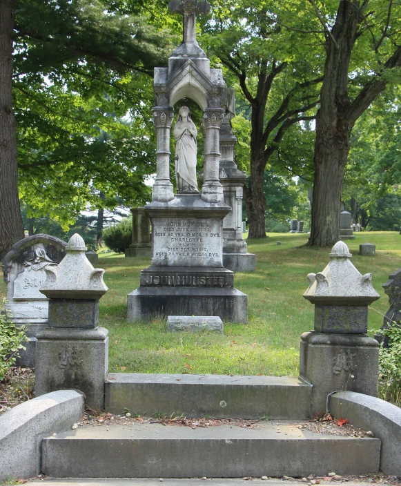 a sculpture with a statue woman in a white gown sitting on a concrete step