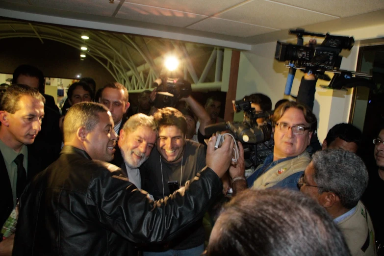 a group of men holding up cameras to take a picture