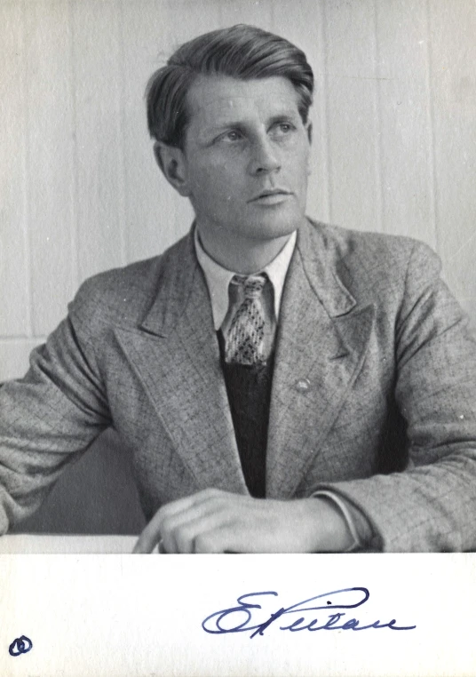black and white pograph of a man in suit with arms crossed