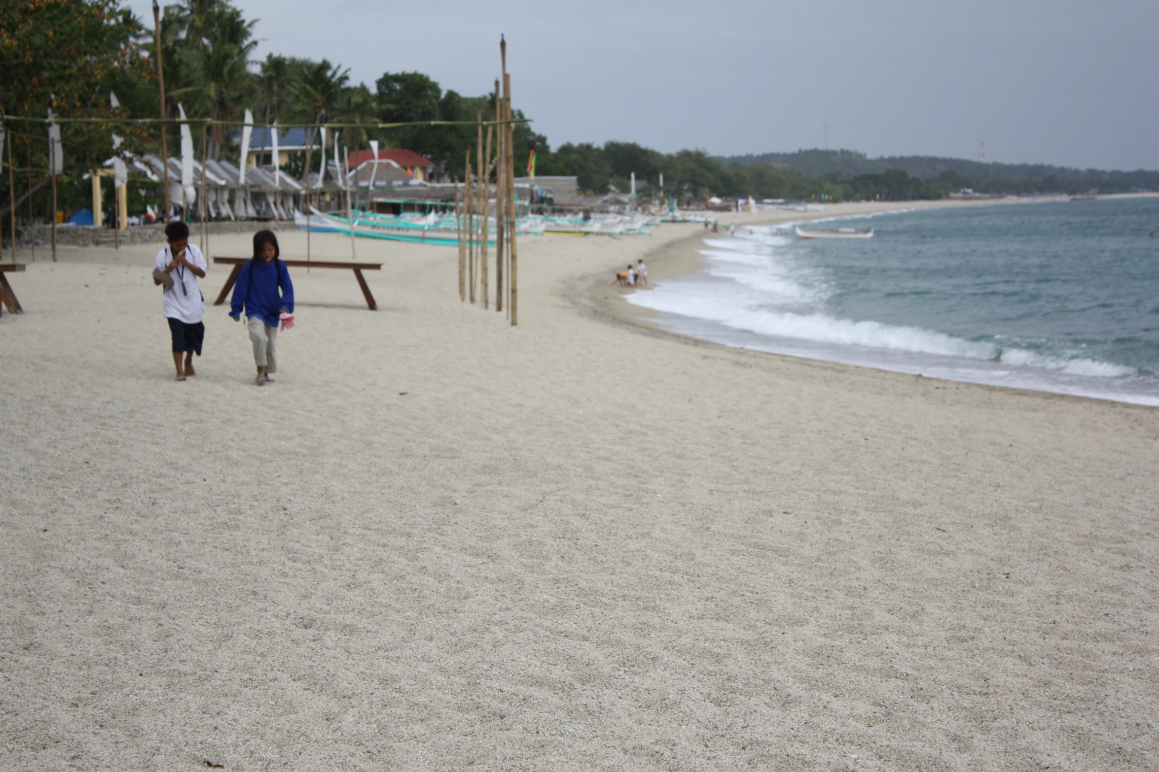 a couple of people that are walking on the beach