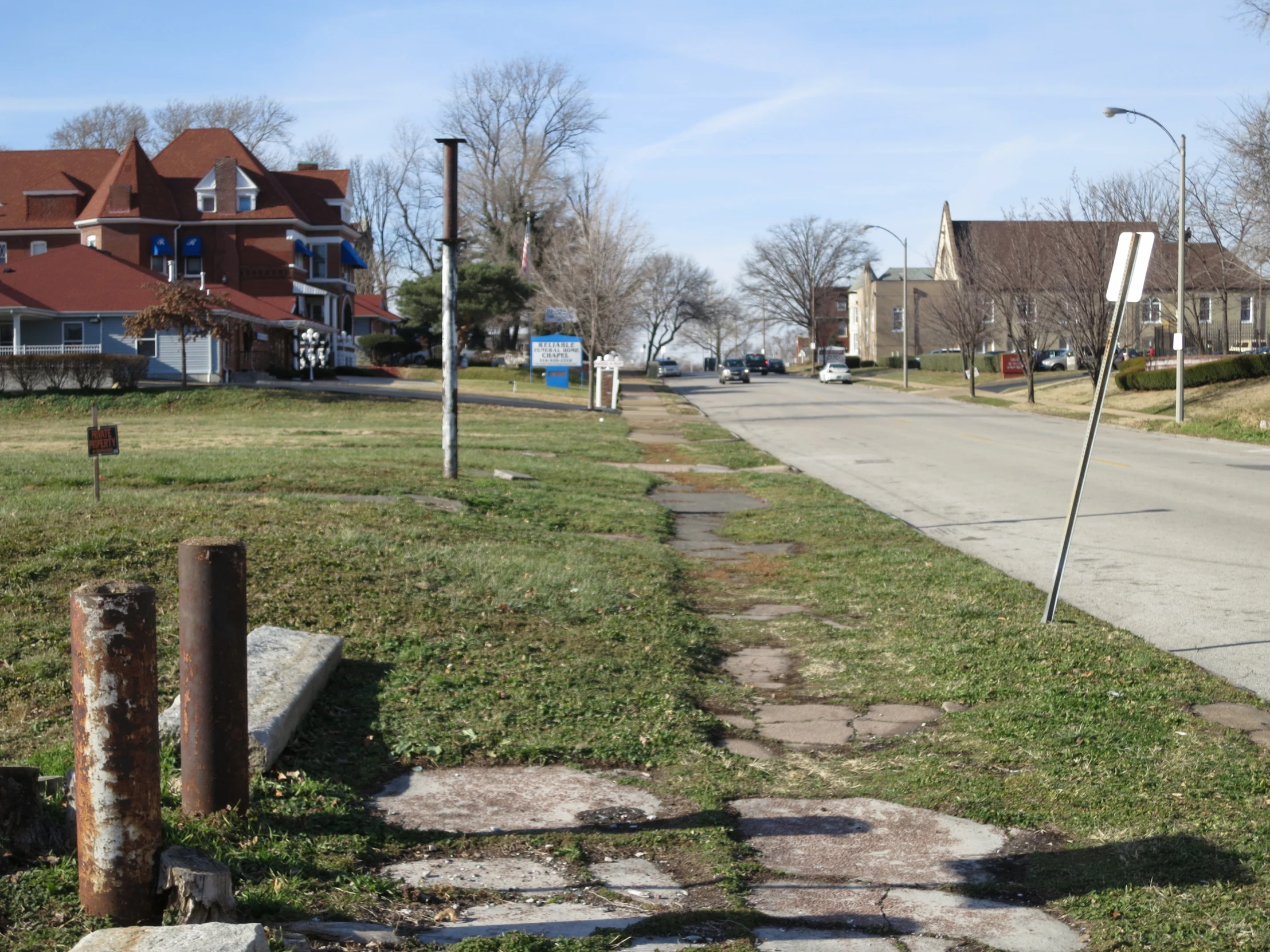 the street is clean and empty and the grass was green