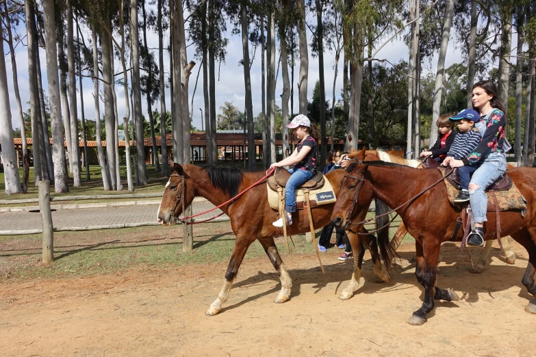 people on horses are riding past a gate