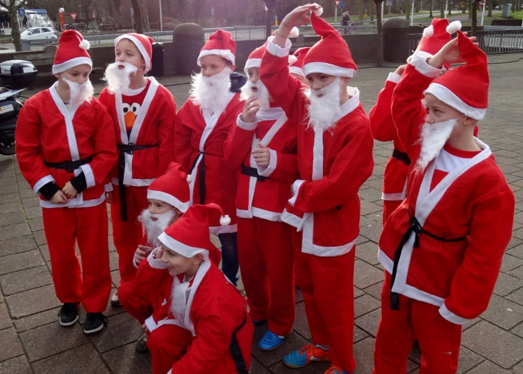 a group of children dressed in red and white santa costumes