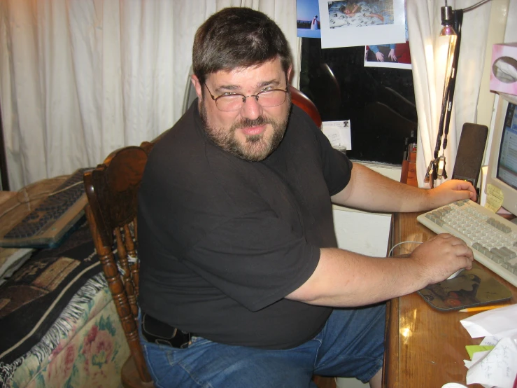 a man leaning up against a wall near a desk