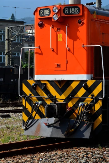 an orange train car sitting on top of train tracks