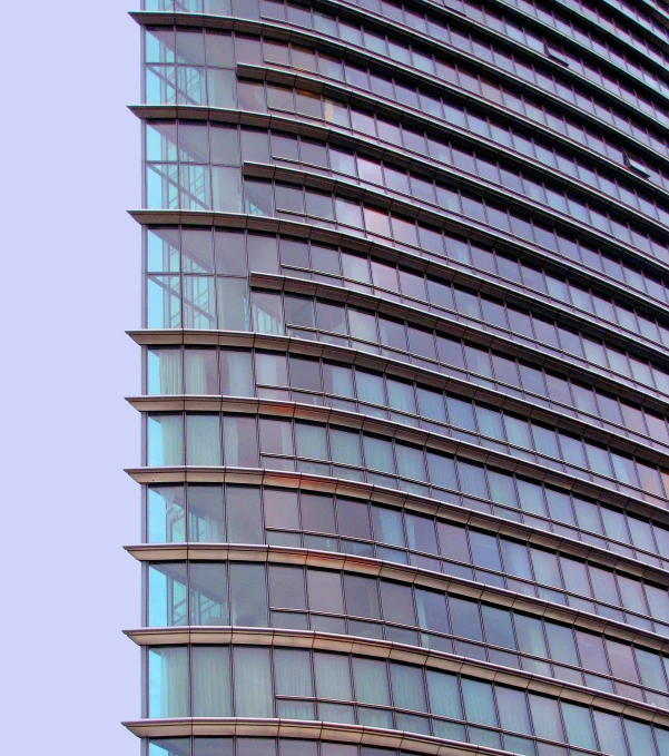 a tall modern building next to a blue sky