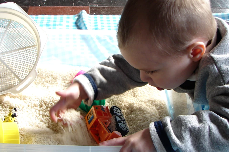 a small child playing with his toys in his play room