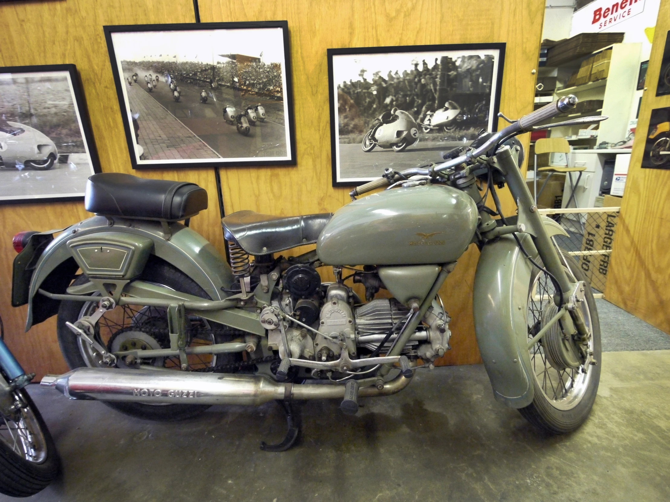 an old motorcycle in a showroom near posters