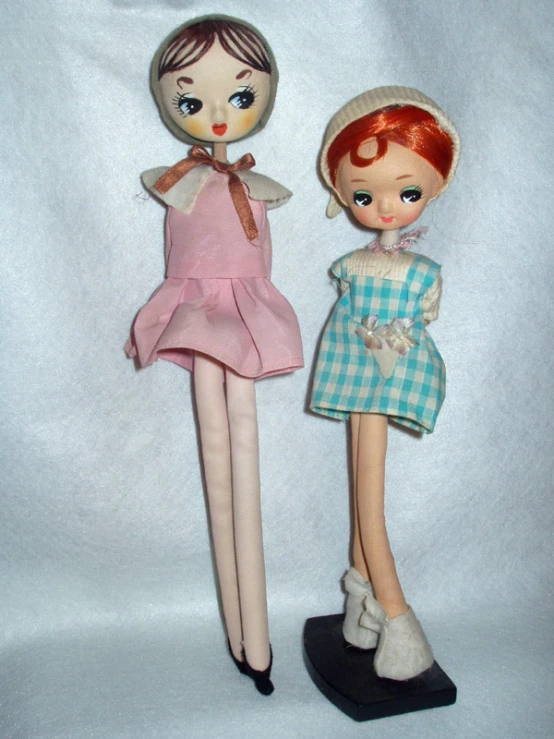 two small dolls stand beside each other