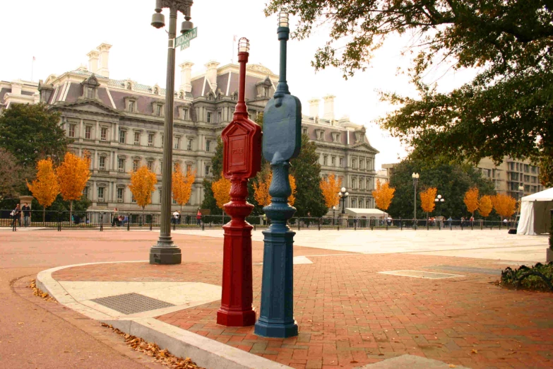 two large street lamps on a brick sidewalk in front of a building