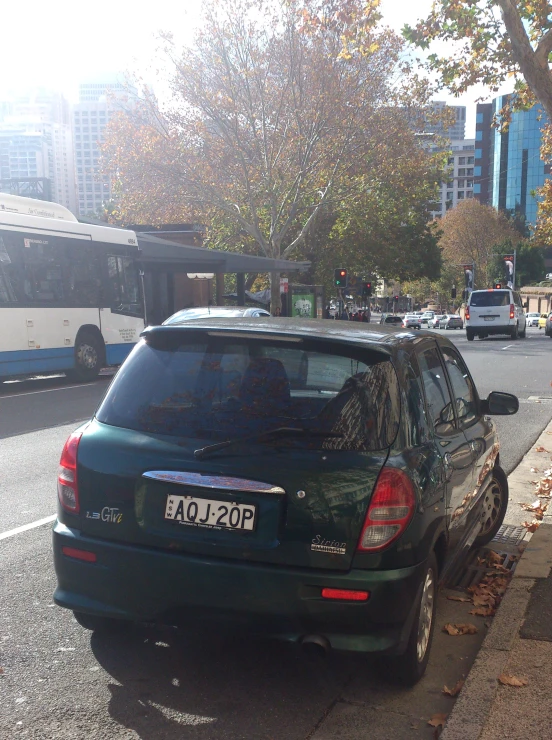 a car is parked on the street in front of a bus