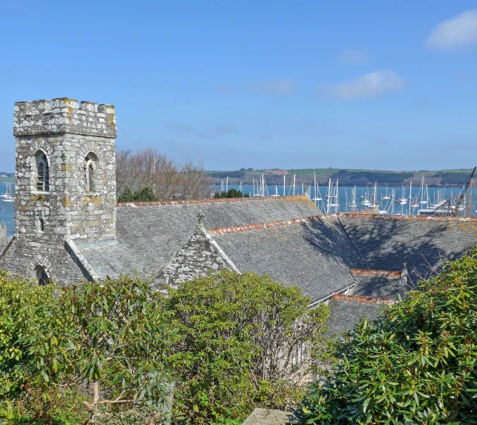 a church sits next to some trees and boats