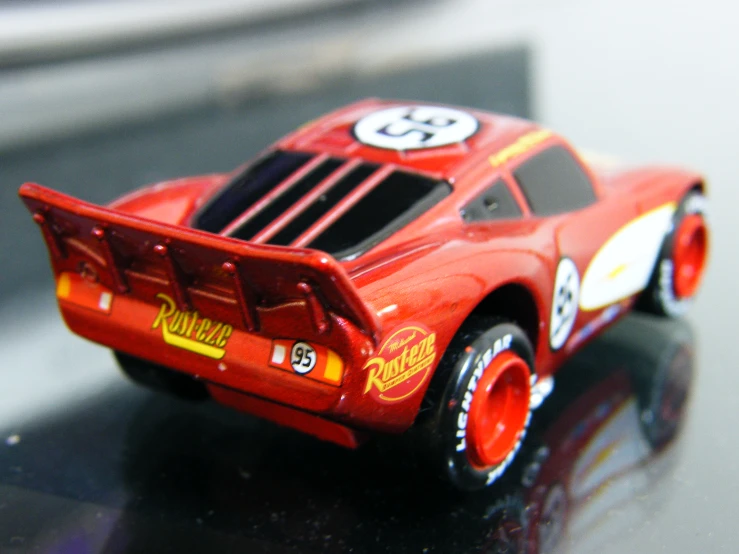 a toy car sits on a table, with its wheels down