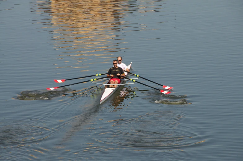 two people in a boat with paddles on the water