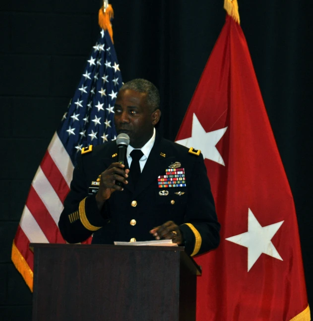 an officer in uniform speaks at a podium