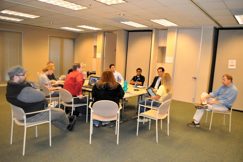 many people are gathered around a table with laptops