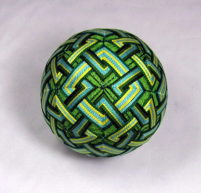 a green ball of yarn with blue and yellow designs