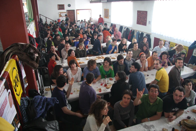 a bunch of people gathered at tables to eat food