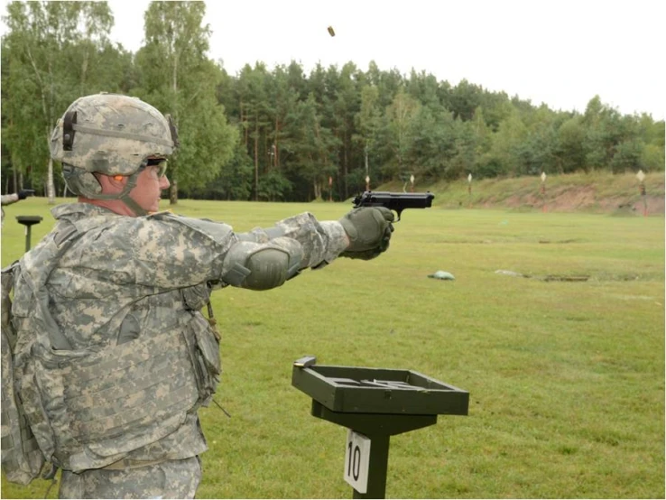 the man is practicing his rifle and aiming it