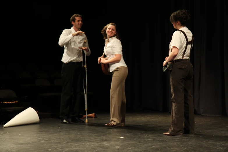 two people standing on a stage with one of them leaning forward