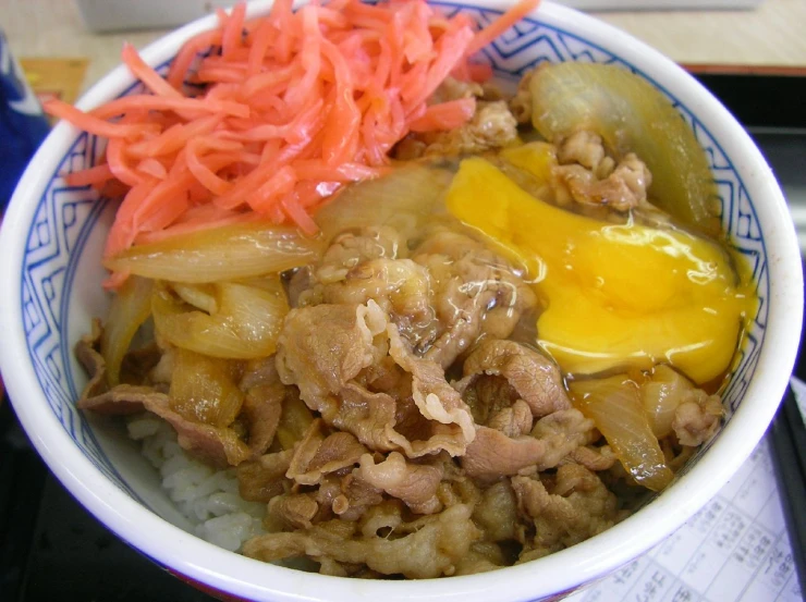 a bowl filled with meat and vegetables on top of rice