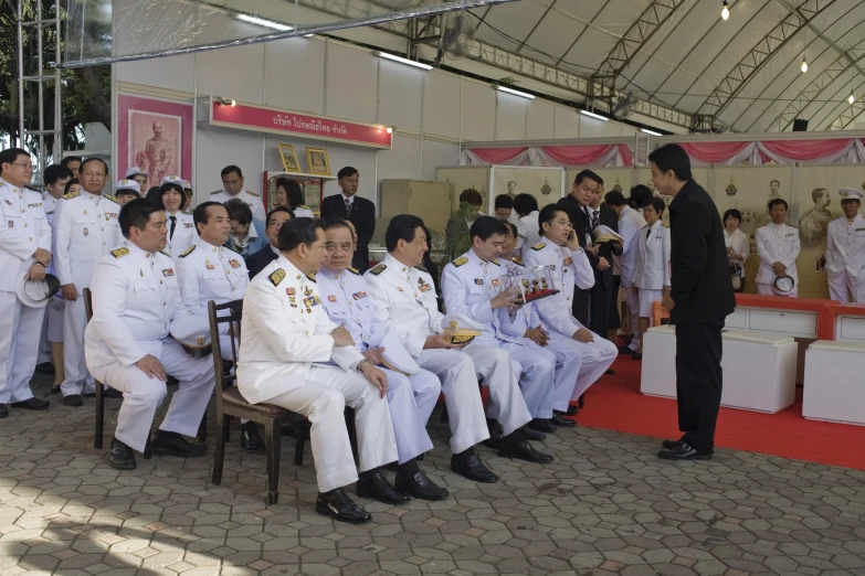 a group of people in white uniforms sitting around