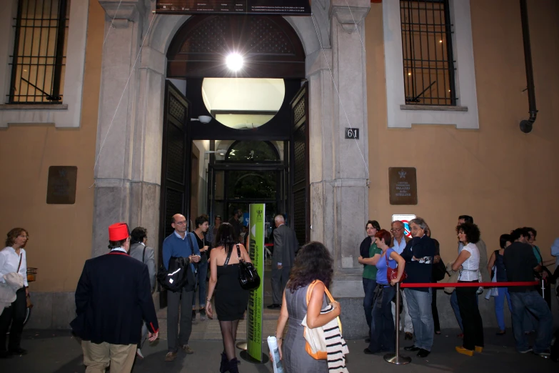 there are many people waiting in front of the entrance of a building