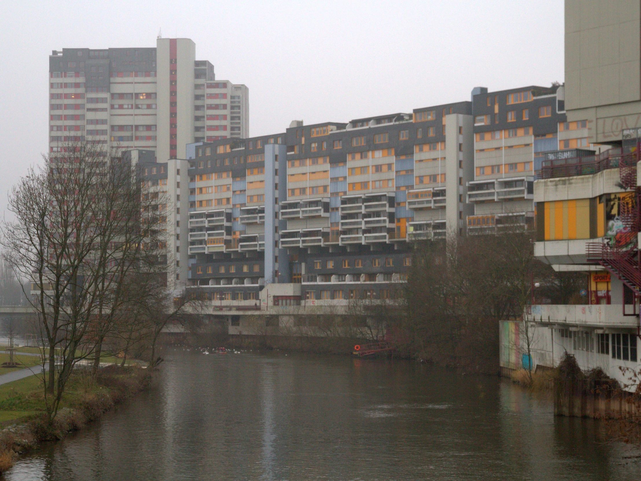 a body of water with a building and trees in the background