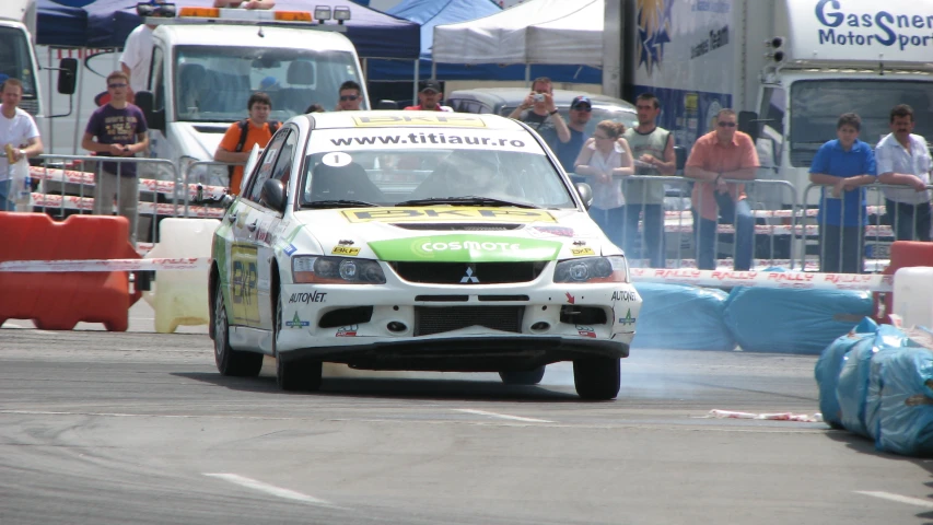 a man driving a rally car through the street