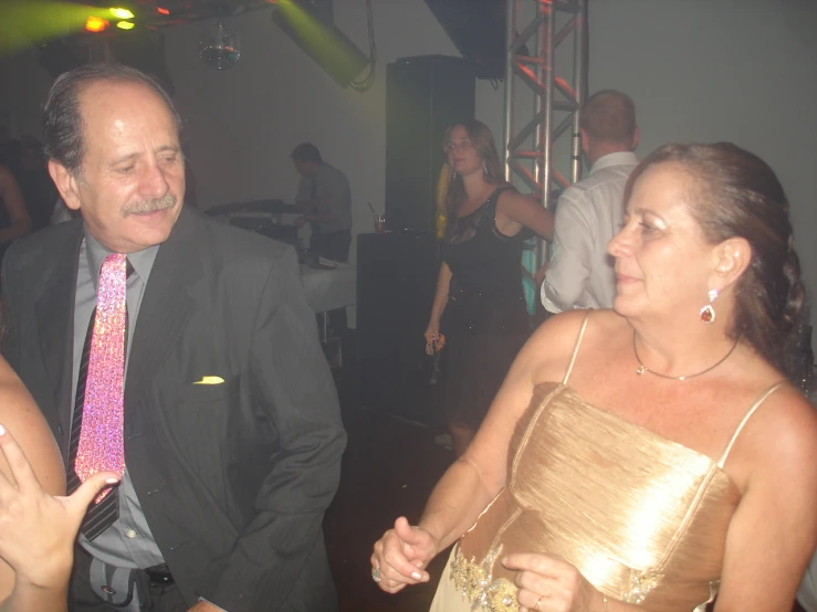 a couple wearing formal wear dancing at a party