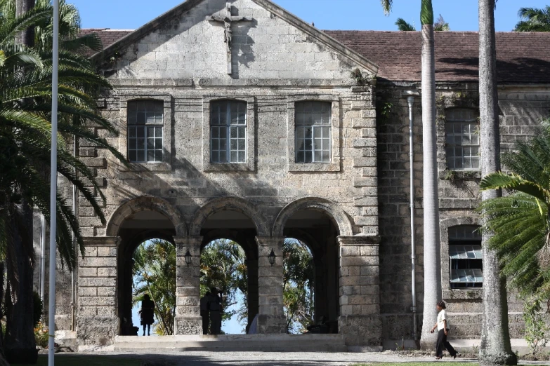 an old building with arches and a cross above the entrance