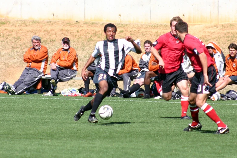 two men playing soccer on a field of grass