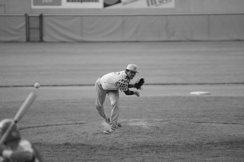 baseball pitcher throwing ball with bat in hand