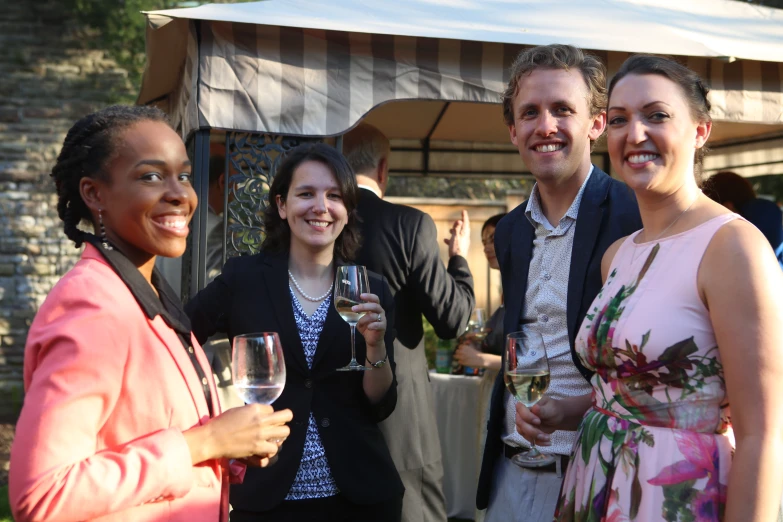 the three people are all wearing suits and holding glasses of wine